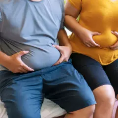 Osoby z nadwagą trzymają się za brzuchy. Zastanawiają się, czy bieżnia odchudza brzuch.