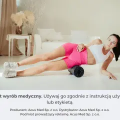 Kobieta pokazuje, jak rolować nogi na rollerze. Ćwiczenie na mięśnie ud.