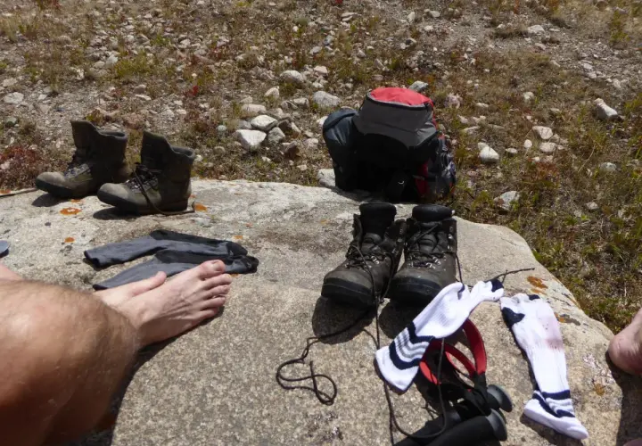 Buty trekkingowe i skarpety na skale. Czas na przewietrzenie stóp i zastanowienie, jak pozbyć się zapachu z butów po długiej wędrówce.