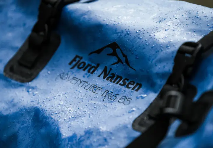 Niebieska torba Fjord Nansen Adventure Bag 65 z kropelkami wody. Waterproof to znaczy, że nic jej nie straszne.