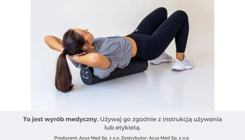 Kobieta leży na wałku do masażu, próbując rozluźnić mięśnie pleców.