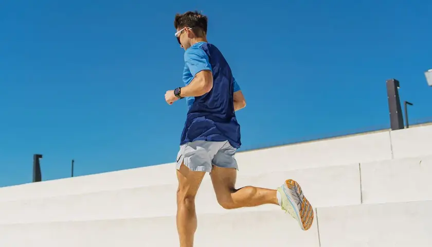 Mężczyzna w sportowym stroju biegnie, jego stopa neutralna pewnie stawia kroki.