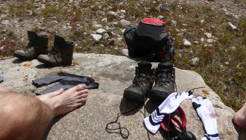 Buty trekkingowe i skarpety na skale. Czas na przewietrzenie stóp i zastanowienie, jak pozbyć się zapachu z butów po długiej wędrówce.
