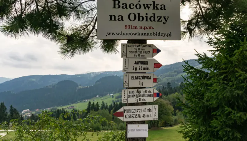 Znaki szlaków turystycznych w górach, wskazujące drogę do Radziejowej i innych miejsc.