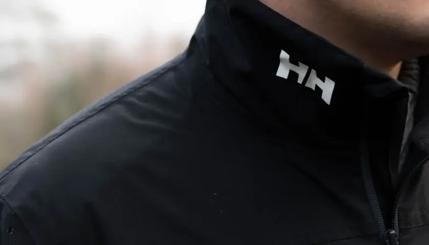 Czarna kurtka z białym logo HH. Helly Hansen co to za firma? To marka odzieży technicznej, idealna na przygody.