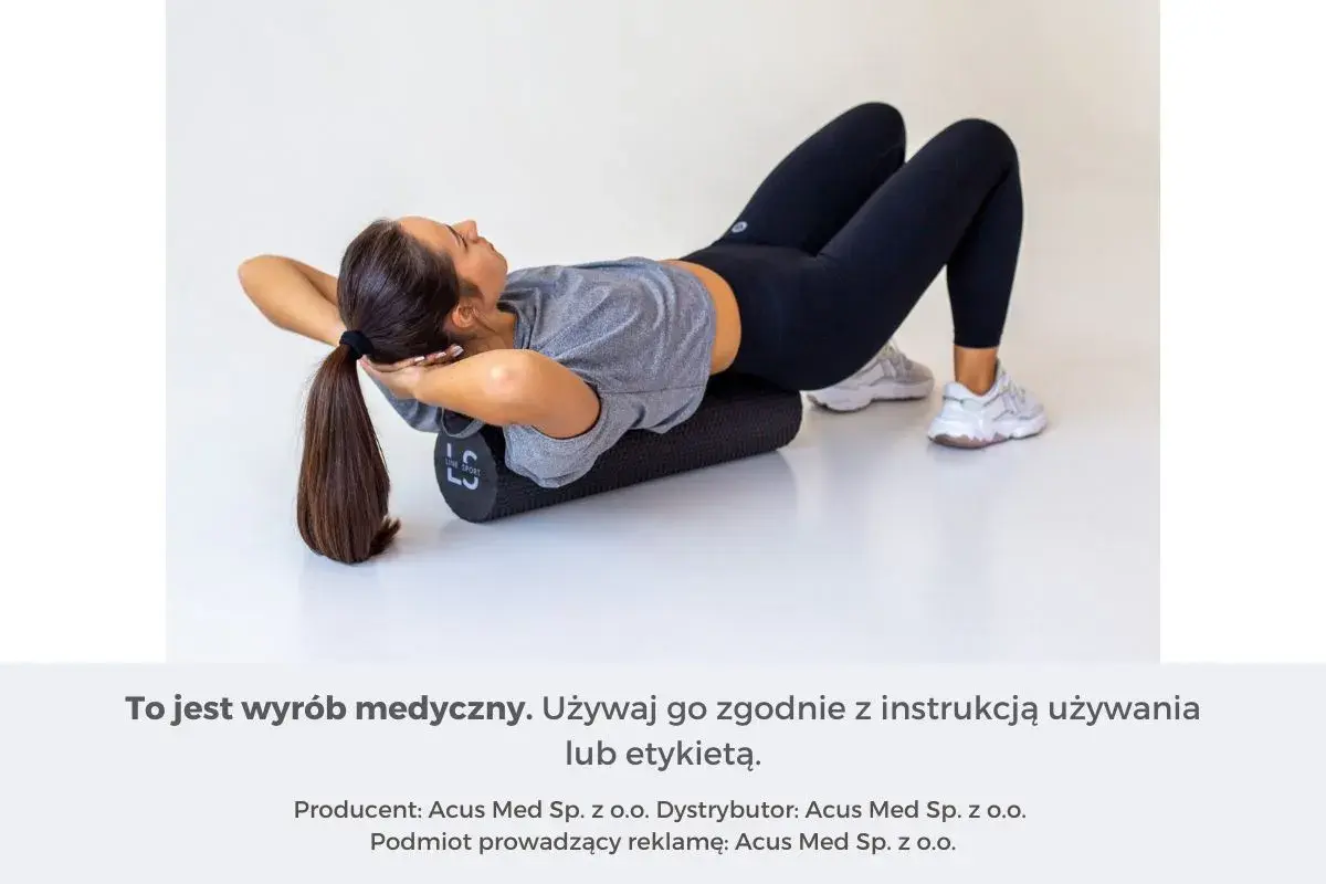 Kobieta leży na wałku do masażu, próbując rozluźnić mięśnie pleców.