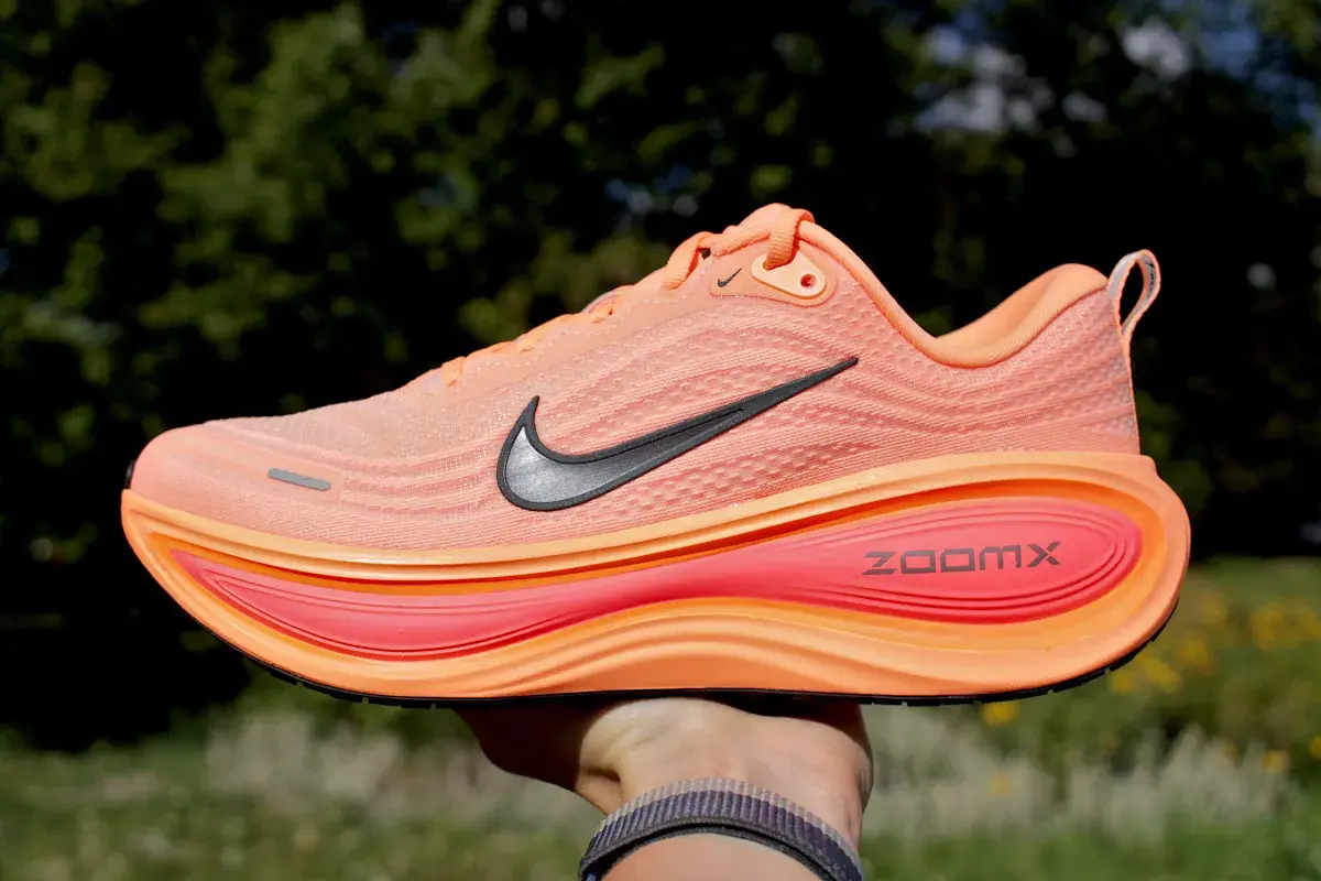 Pomarańczowe buty na bieżnię elektryczną z czarnym logo Nike i napisem ZoomX. Idealne do treningów.