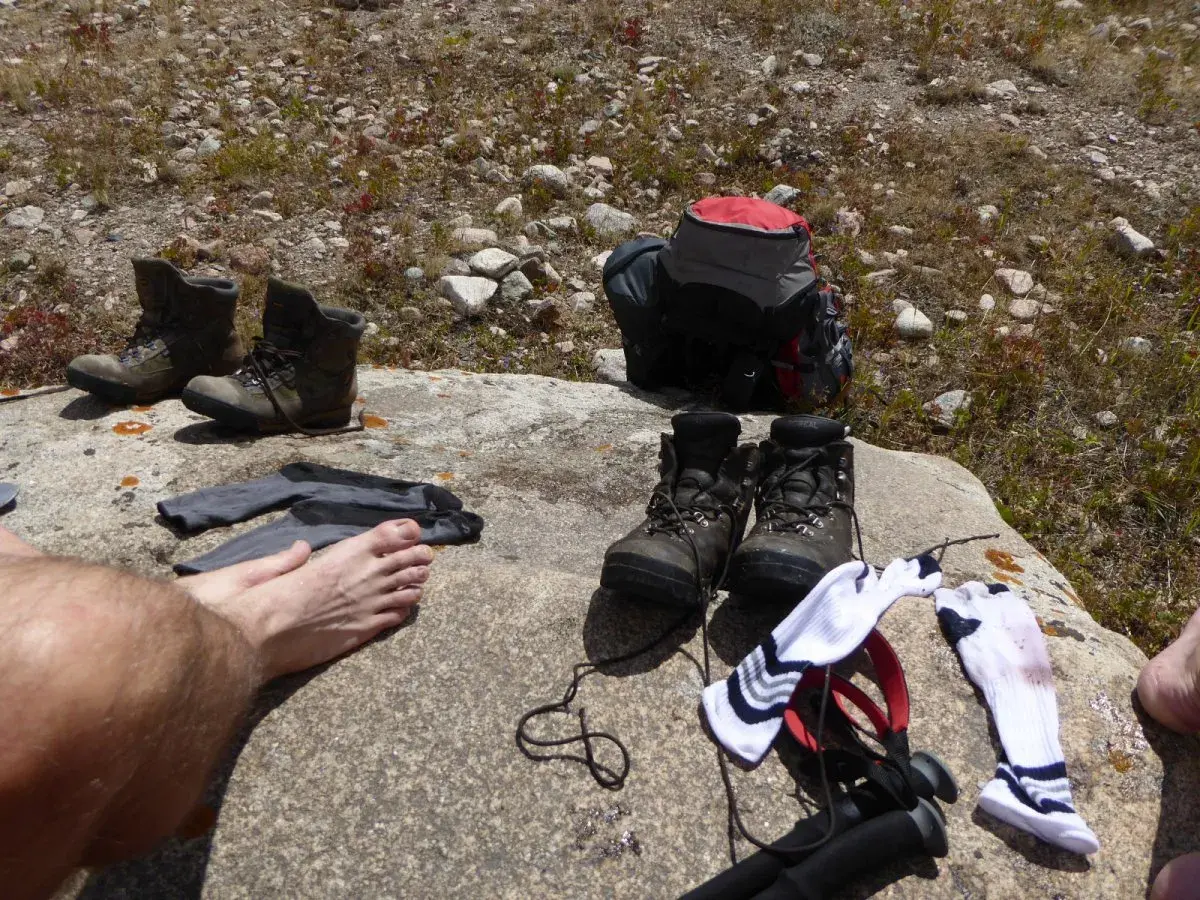 Buty trekkingowe i skarpety na skale. Czas na przewietrzenie stóp i zastanowienie, jak pozbyć się zapachu z butów po długiej wędrówce.