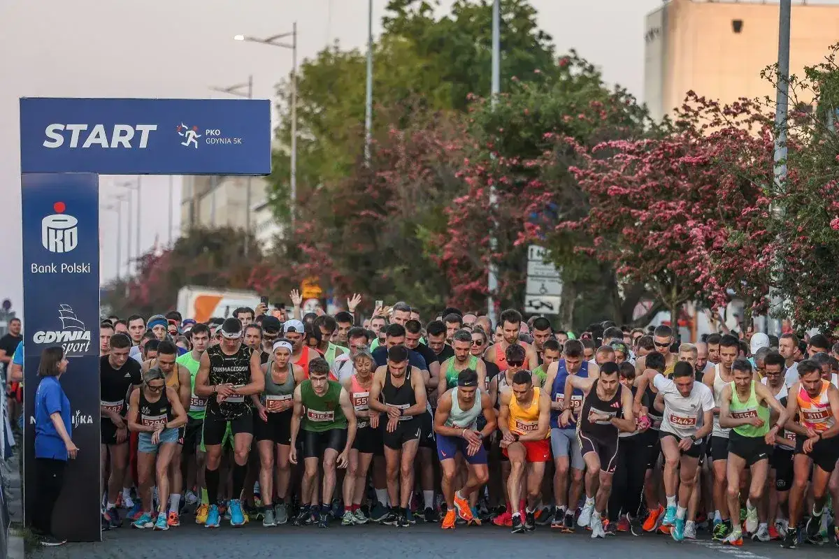 Start biegu w Gdyni, tłum biegaczy gotowych do startu w jednym z wielu półmaratonów w Polsce.