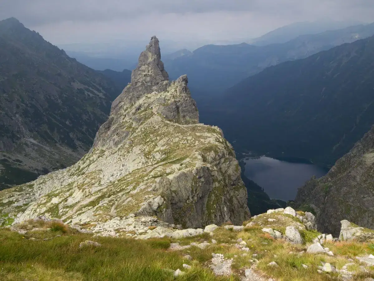 Majestatyczny Mnich Szczyt góruje nad doliną, gdzie w dole lśni ciemne jezioro.