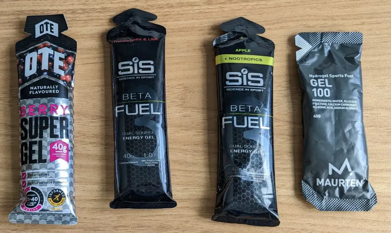 Cztery opakowania żeli energetycznych dla biegaczy: OTE Berry Super Gel, SiS Beta Fuel (truskawka-limonka i jabłko z nootropikami) oraz Maurten Gel 100.